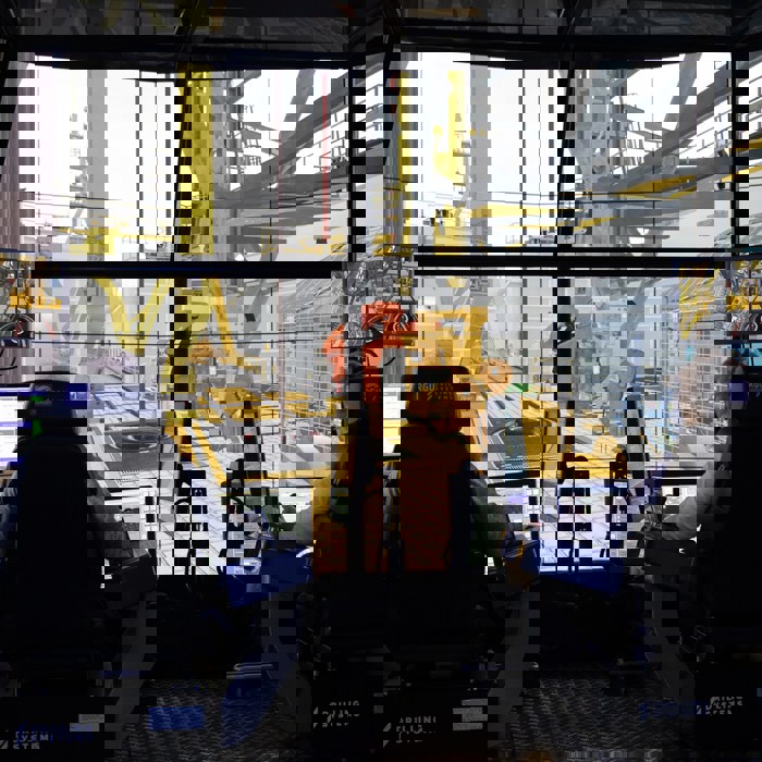 Two people engage in a simulated offshore drilling control room, utilizing multiple screens and realistic visuals of equipment to enhance their training experience.