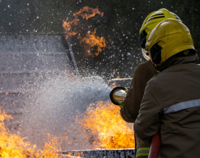 two firefighters putting out a fire for emergency response training