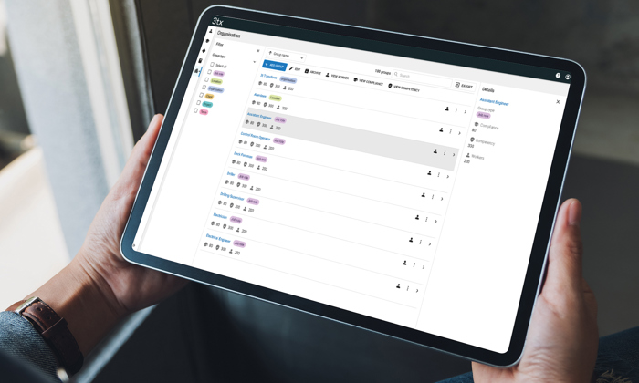 Person holding a tablet displaying a task management application with a list of tasks and their statuses.