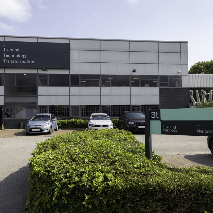 External photo of grey building with car park