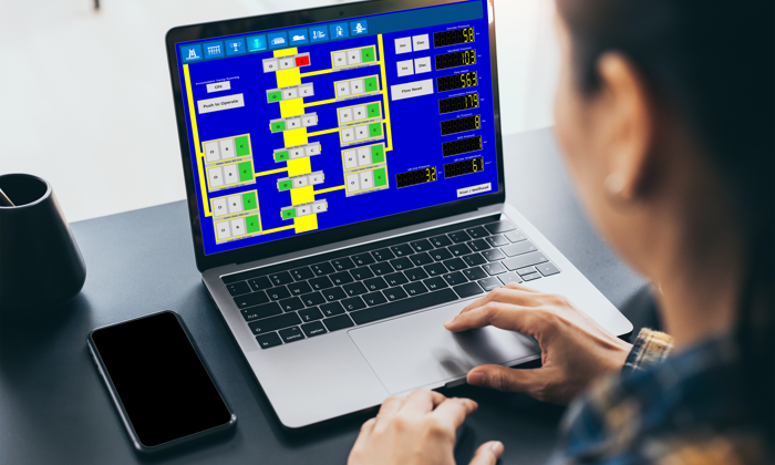 A person uses a laptop displaying a complex blue and yellow flowchart.