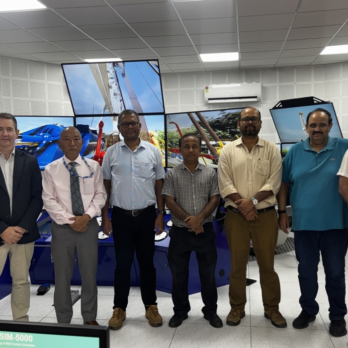 eight men standing in front on large simulator screens