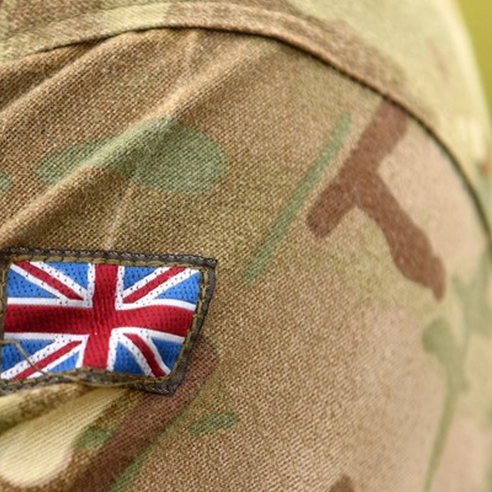 Close-up of a camouflage uniform sleeve featuring a Union Jack patch.